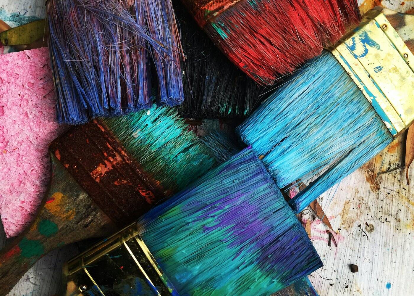 Well-used paint brushes in many colours